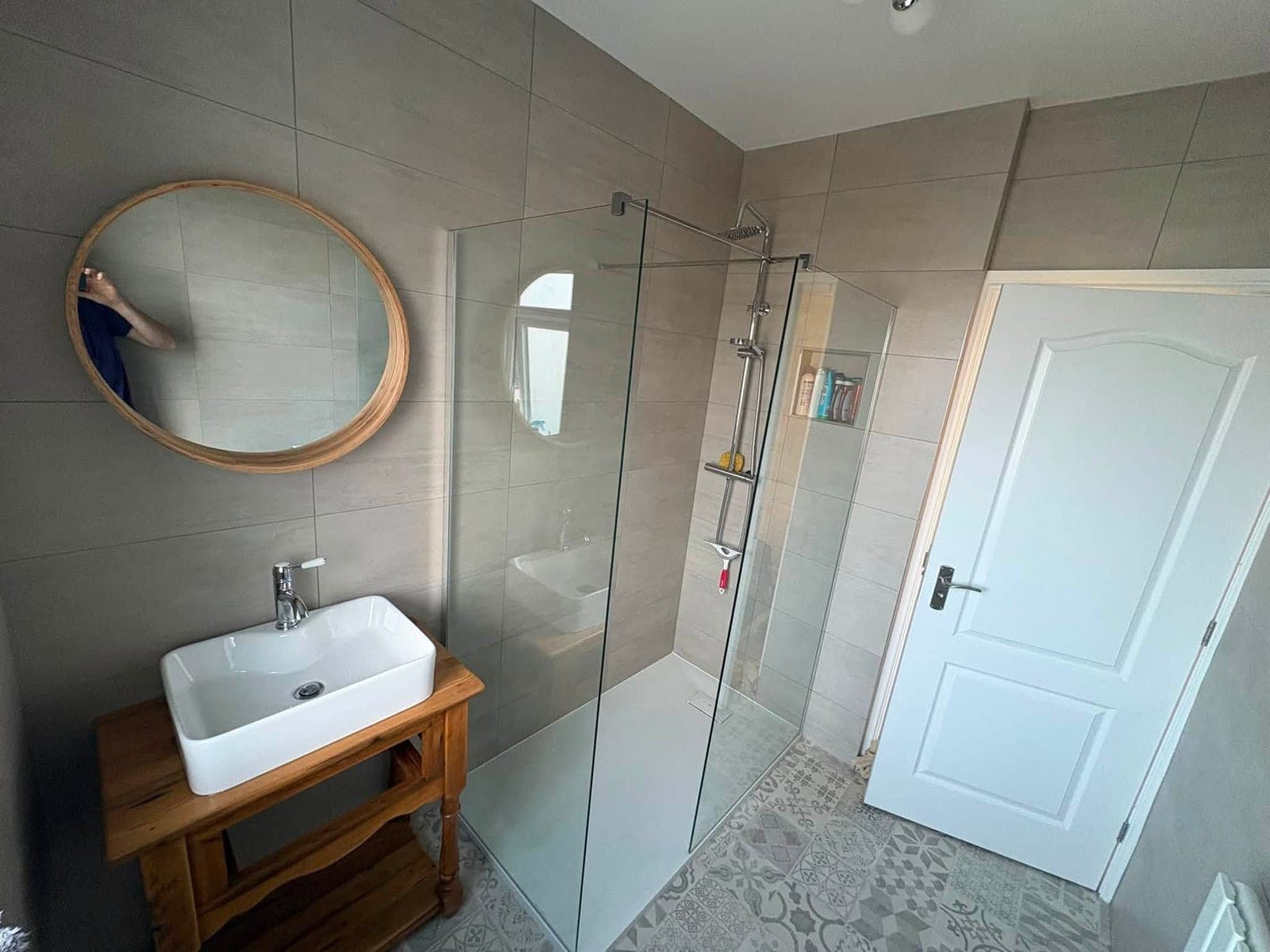 Finished walk-in shower with a glass screen