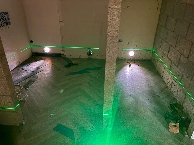 Laser level lines marked across a stripped bathroom